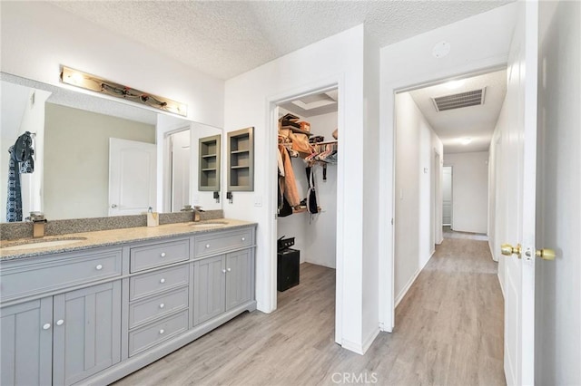 bathroom featuring vanity, hardwood / wood-style flooring, and a textured ceiling