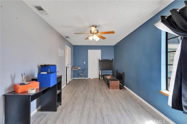 interior space with ceiling fan, light hardwood / wood-style floors, and a textured ceiling