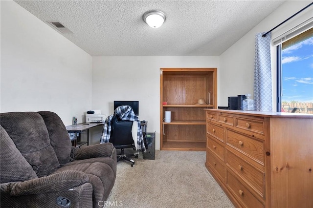 carpeted office space with a textured ceiling