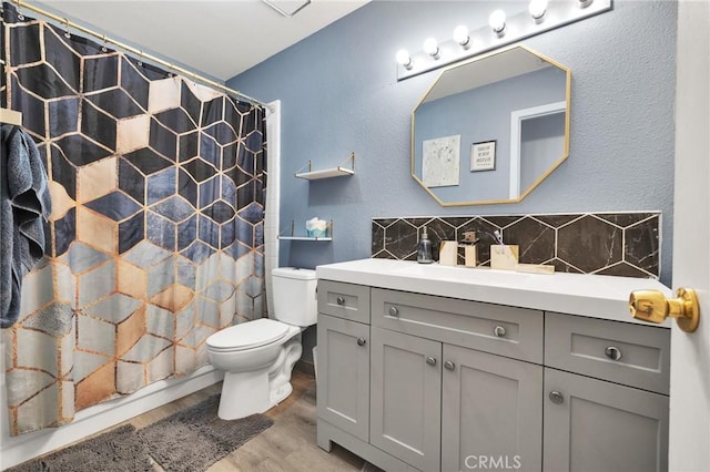 bathroom featuring hardwood / wood-style flooring, vanity, decorative backsplash, a shower with curtain, and toilet