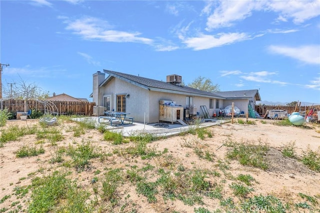 rear view of house with central air condition unit and a patio area