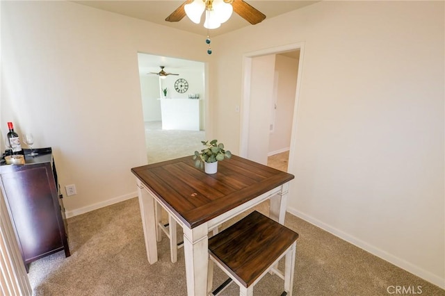 dining area featuring light colored carpet and ceiling fan