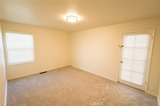 unfurnished room featuring light carpet