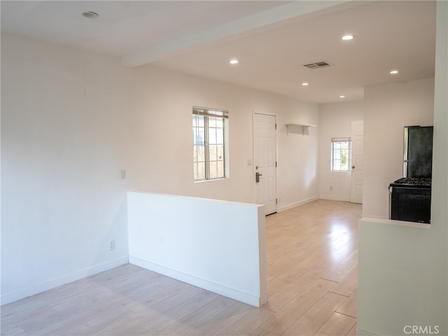 interior space featuring beam ceiling and light wood-type flooring