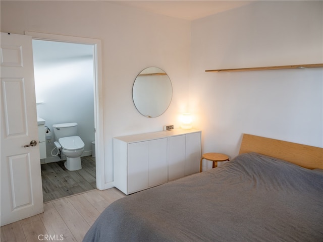 bedroom featuring ensuite bath and light wood-type flooring