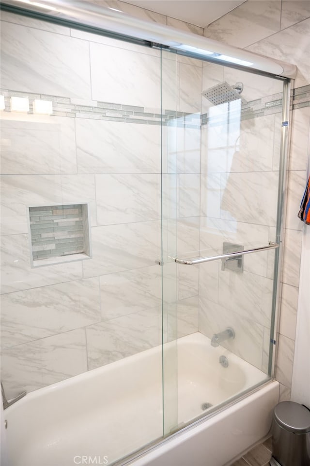 bathroom featuring bath / shower combo with glass door