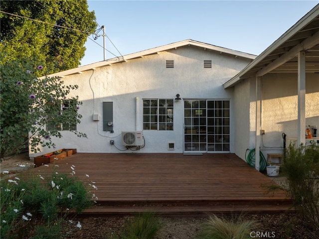 rear view of house with a wooden deck and ac unit