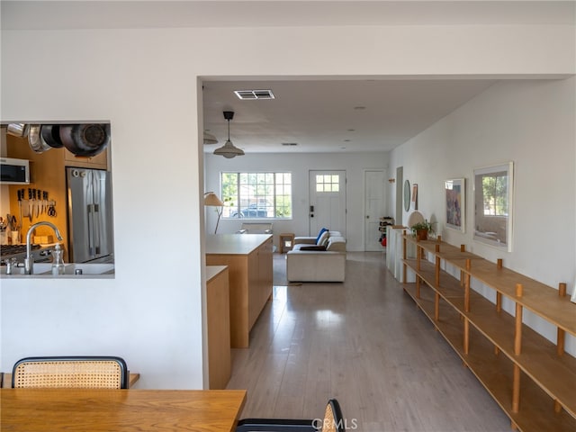 hallway with sink and hardwood / wood-style flooring