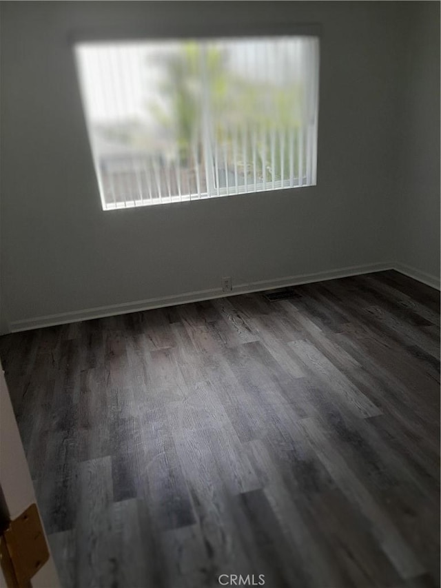 spare room with wood finished floors and baseboards