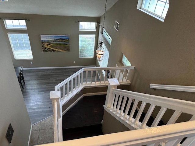 stairs featuring hardwood / wood-style flooring and a healthy amount of sunlight