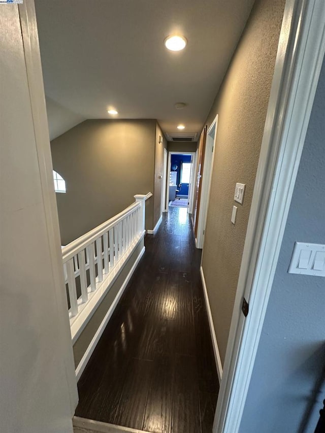 hall featuring vaulted ceiling and dark hardwood / wood-style flooring