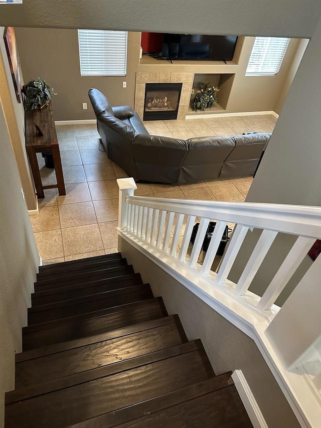 staircase with tile patterned floors and a tile fireplace