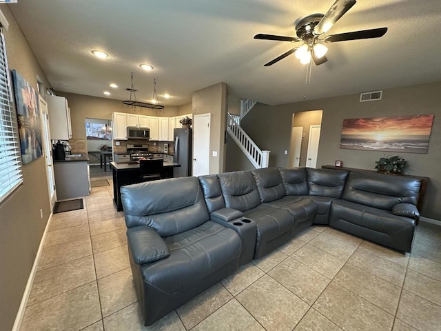 living room with light tile patterned floors, a textured ceiling, and ceiling fan