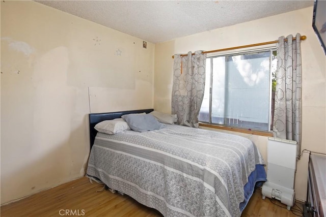 bedroom featuring hardwood / wood-style flooring and a textured ceiling