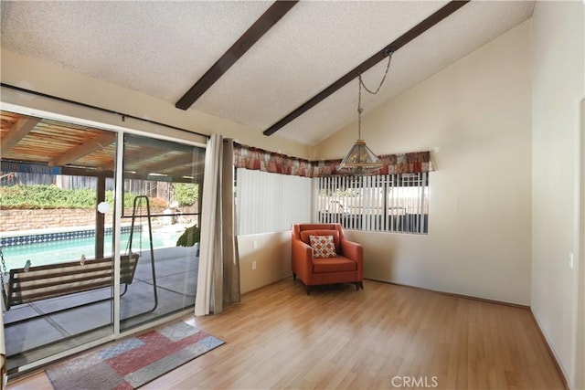 doorway featuring hardwood / wood-style floors, a textured ceiling, and vaulted ceiling with beams