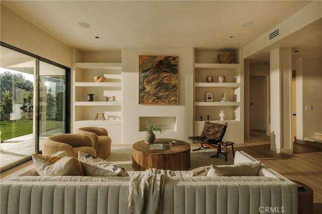 living room with hardwood / wood-style flooring and built in features