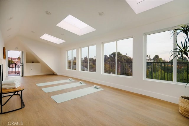 additional living space featuring vaulted ceiling and light hardwood / wood-style flooring