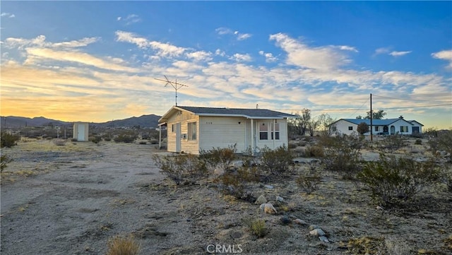 property exterior at dusk featuring a mountain view