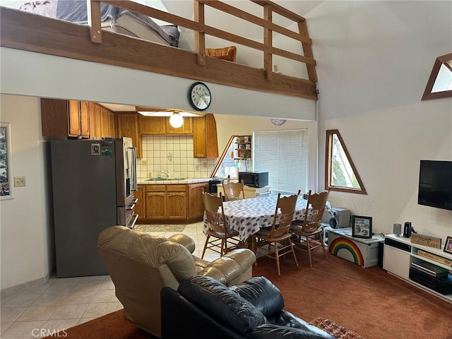 living room featuring light tile patterned flooring, sink, and high vaulted ceiling