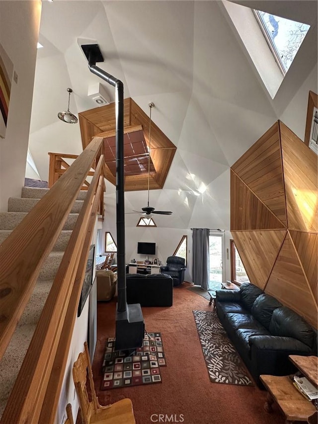 carpeted living room featuring high vaulted ceiling and a skylight