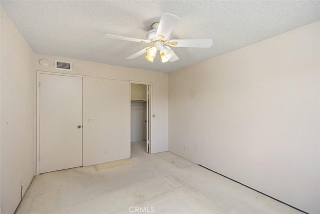 unfurnished bedroom featuring a closet, ceiling fan, and a textured ceiling