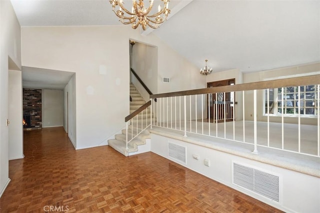 staircase with parquet floors, high vaulted ceiling, and a notable chandelier