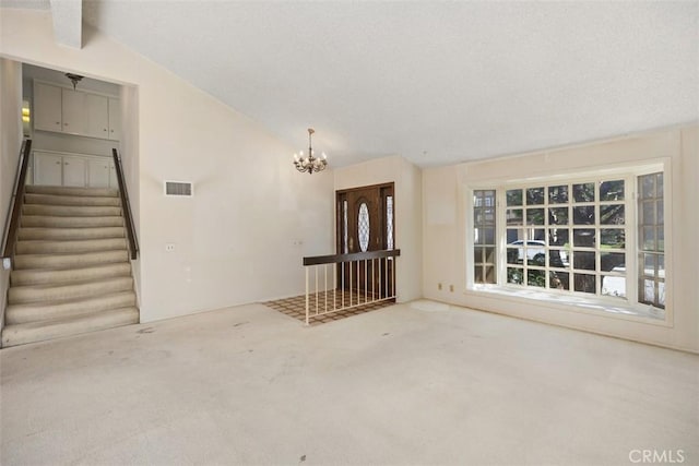 unfurnished room with lofted ceiling with beams, a chandelier, and carpet floors