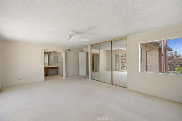 unfurnished bedroom featuring a textured ceiling, a closet, and ceiling fan