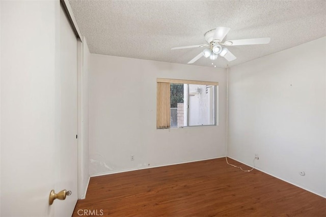 unfurnished room with ceiling fan, dark hardwood / wood-style flooring, and a textured ceiling