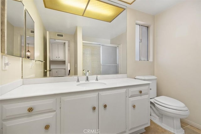 bathroom featuring toilet, tile patterned flooring, vanity, and walk in shower