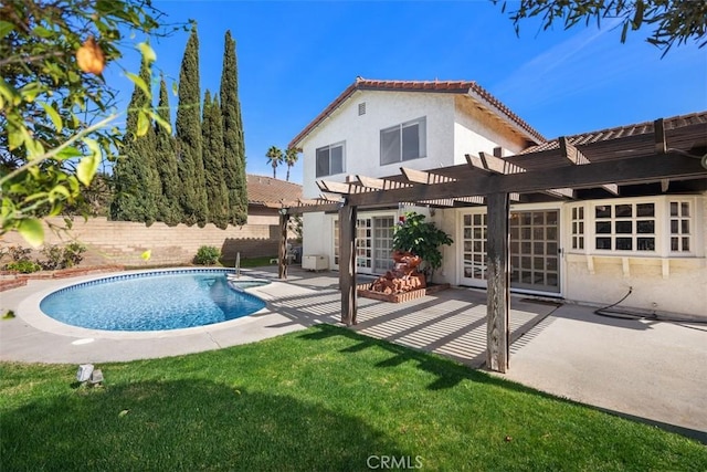 back of property with a yard, a pergola, a fenced in pool, and a patio area