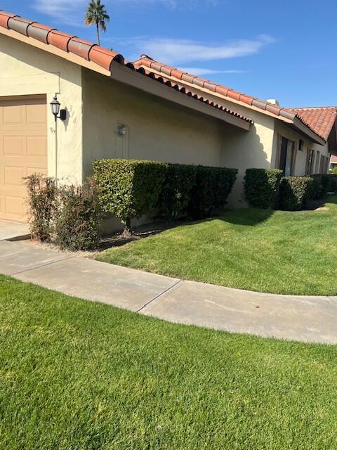 view of side of property featuring a garage and a yard