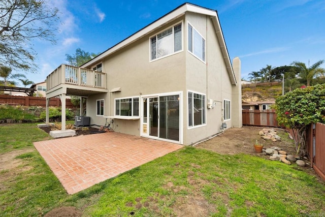 rear view of house featuring a lawn, central air condition unit, and a patio area