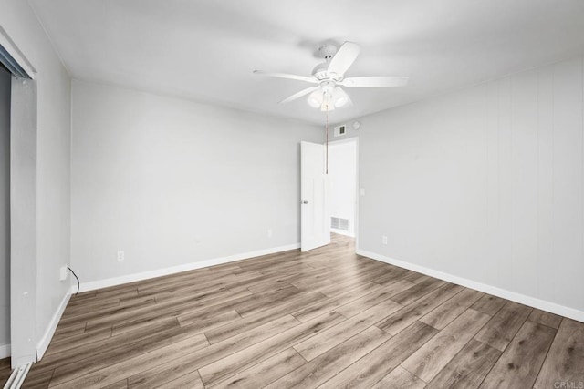 empty room with ceiling fan and light hardwood / wood-style flooring