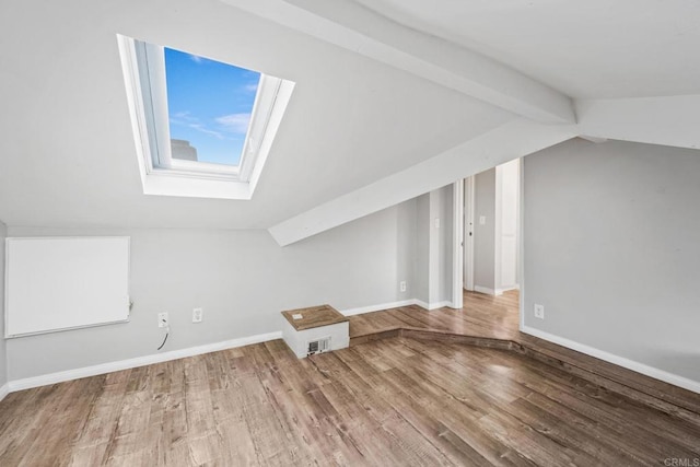 bonus room featuring hardwood / wood-style flooring and vaulted ceiling with skylight