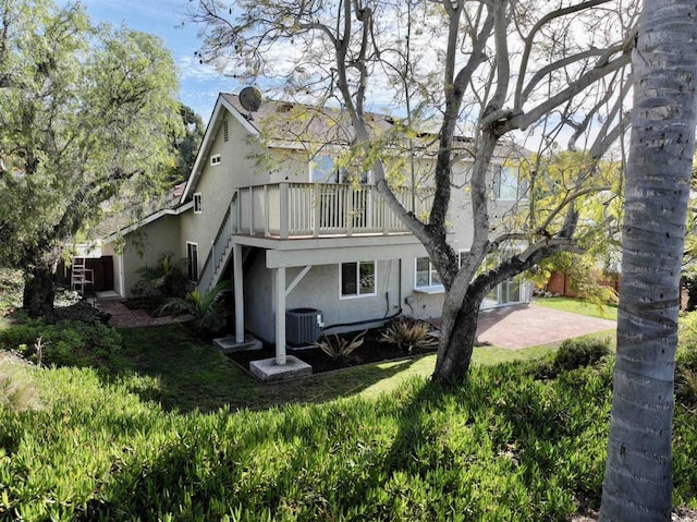 back of property with a patio and central AC