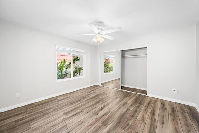 unfurnished bedroom featuring hardwood / wood-style flooring, ceiling fan, and a closet