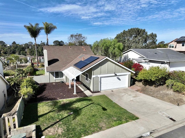 view of front of property featuring a garage, a front lawn, and solar panels