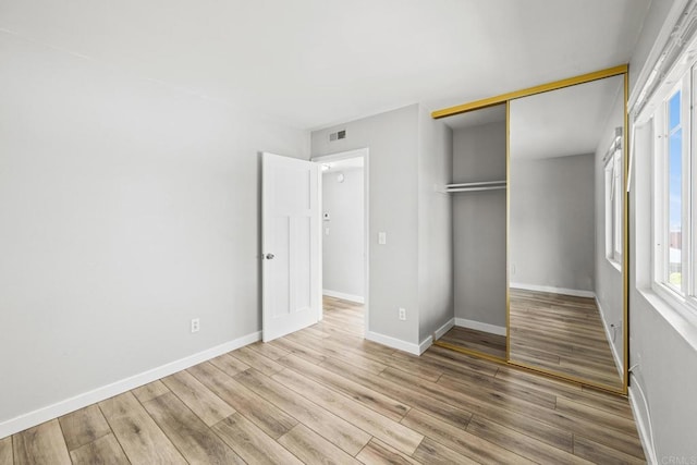 unfurnished bedroom featuring light hardwood / wood-style floors and a closet