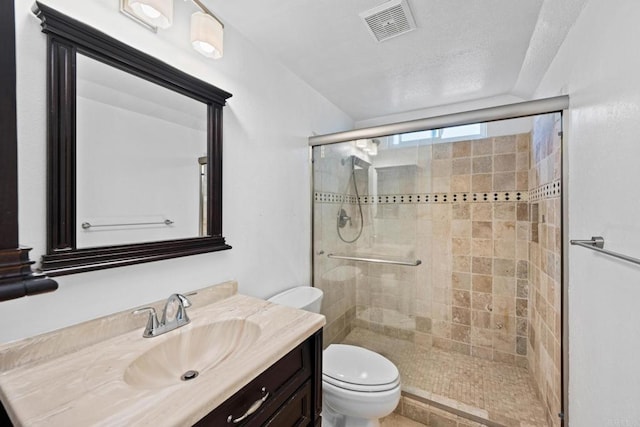 bathroom with vanity, toilet, and a shower with shower door