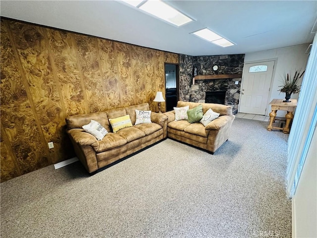 living room featuring carpet flooring, a fireplace, and wood walls