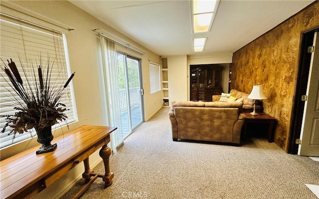 living room featuring light colored carpet and wooden walls