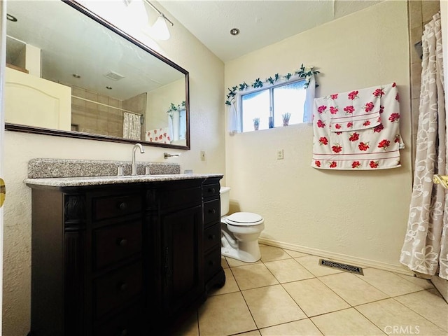 bathroom with tile patterned flooring, vanity, and toilet