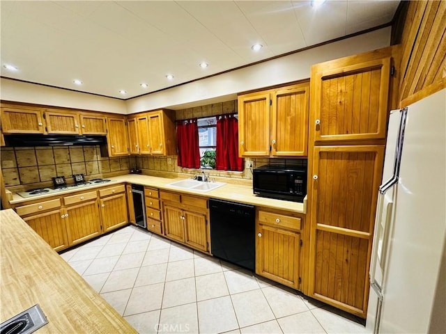 kitchen with sink, light tile patterned floors, backsplash, black appliances, and beverage cooler