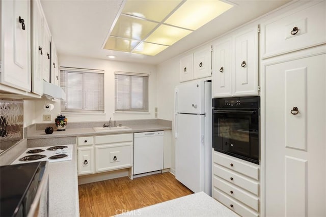 kitchen featuring white cabinetry, sink, white appliances, and light wood-type flooring