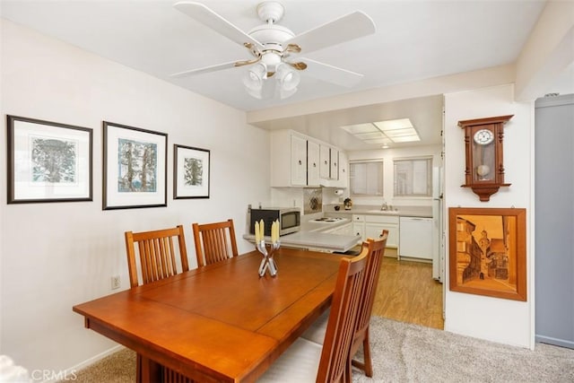 carpeted dining space featuring ceiling fan and sink