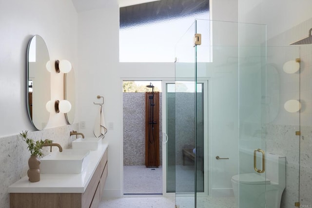 bathroom featuring vanity, an enclosed shower, and toilet