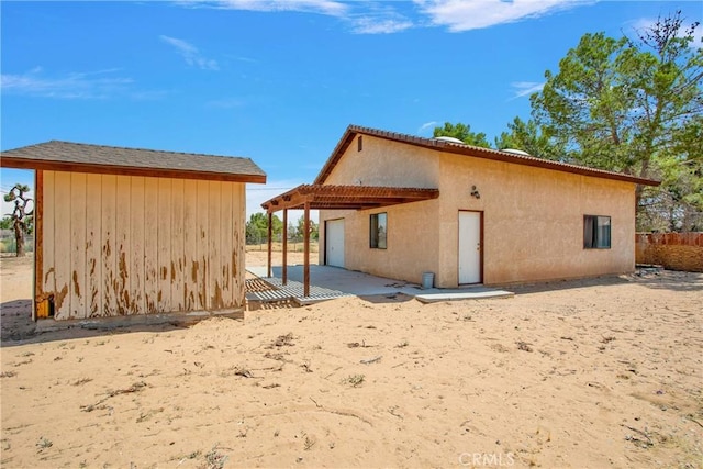 back of property with a pergola and a patio area