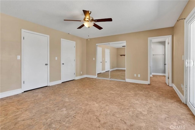 unfurnished bedroom with multiple closets and ceiling fan