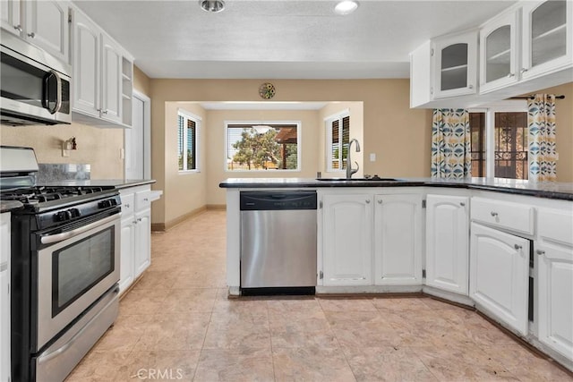 kitchen featuring stainless steel appliances, light tile patterned flooring, sink, and white cabinets